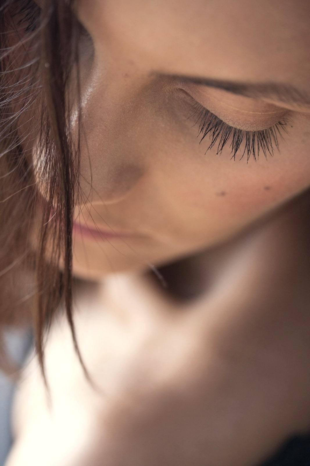 A close-up of long lashes on a downcast face